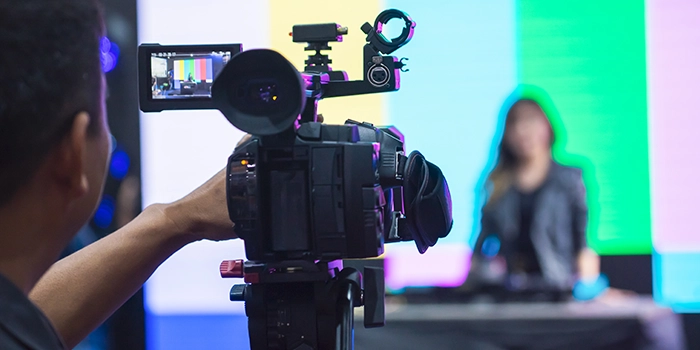 Photograph of NDI video being recorded with cameraman and news anchor