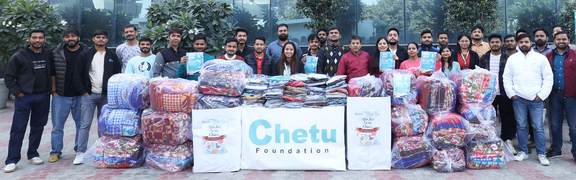 Chetu Team Members proudly display winter essentials collected for distribution to disadvantaged people in Noida.